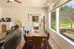 The dining table overlooks the manicured yard and seats 6 guests